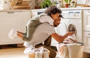Vater mit jungem Sohn beim Entladen einer Waschmaschine